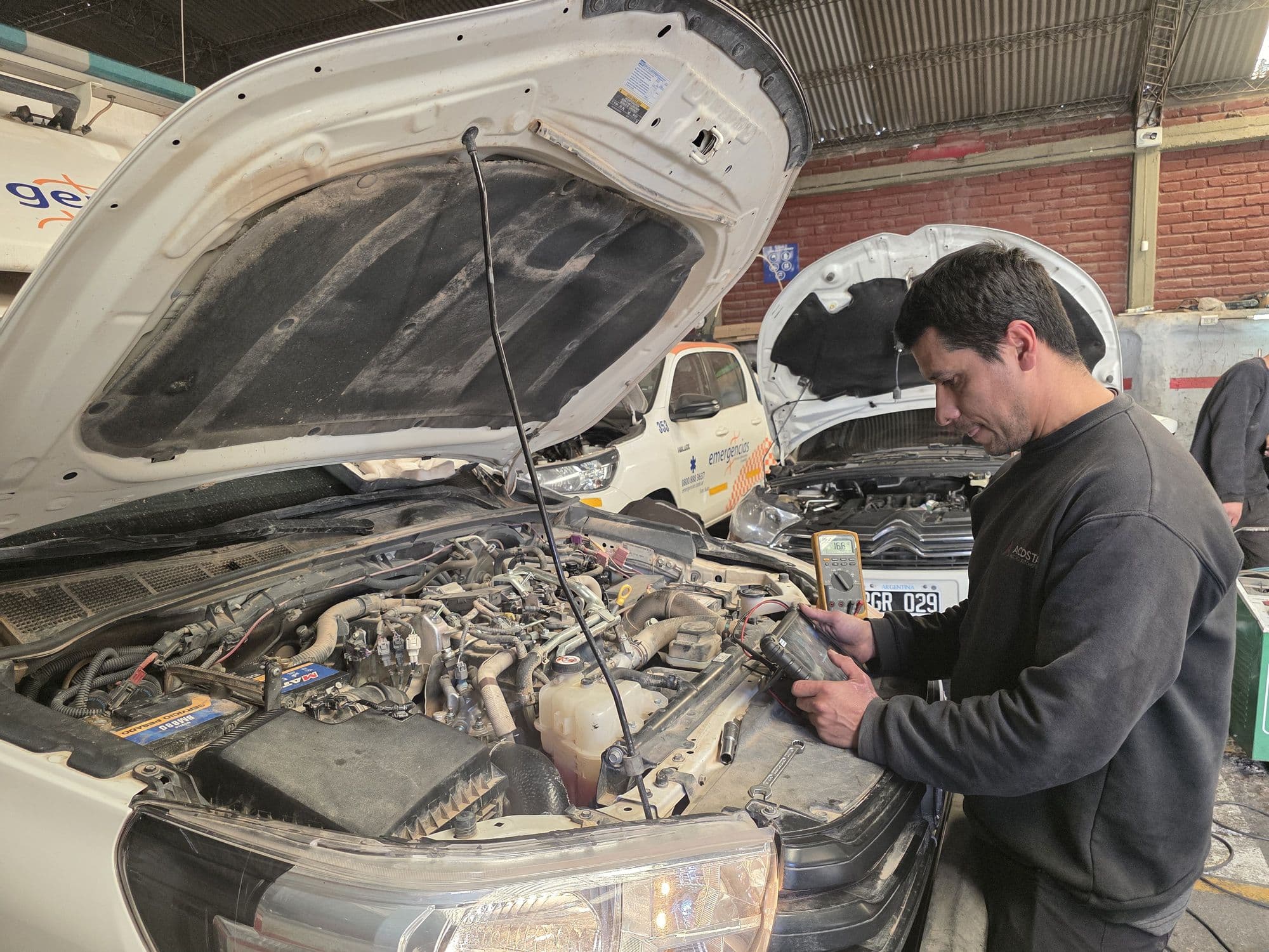 Ricardo Acosta haciendo diagnóstico eléctrico en el taller